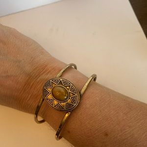 Brass cuff bracelet with yellow-gold stone insde sun image